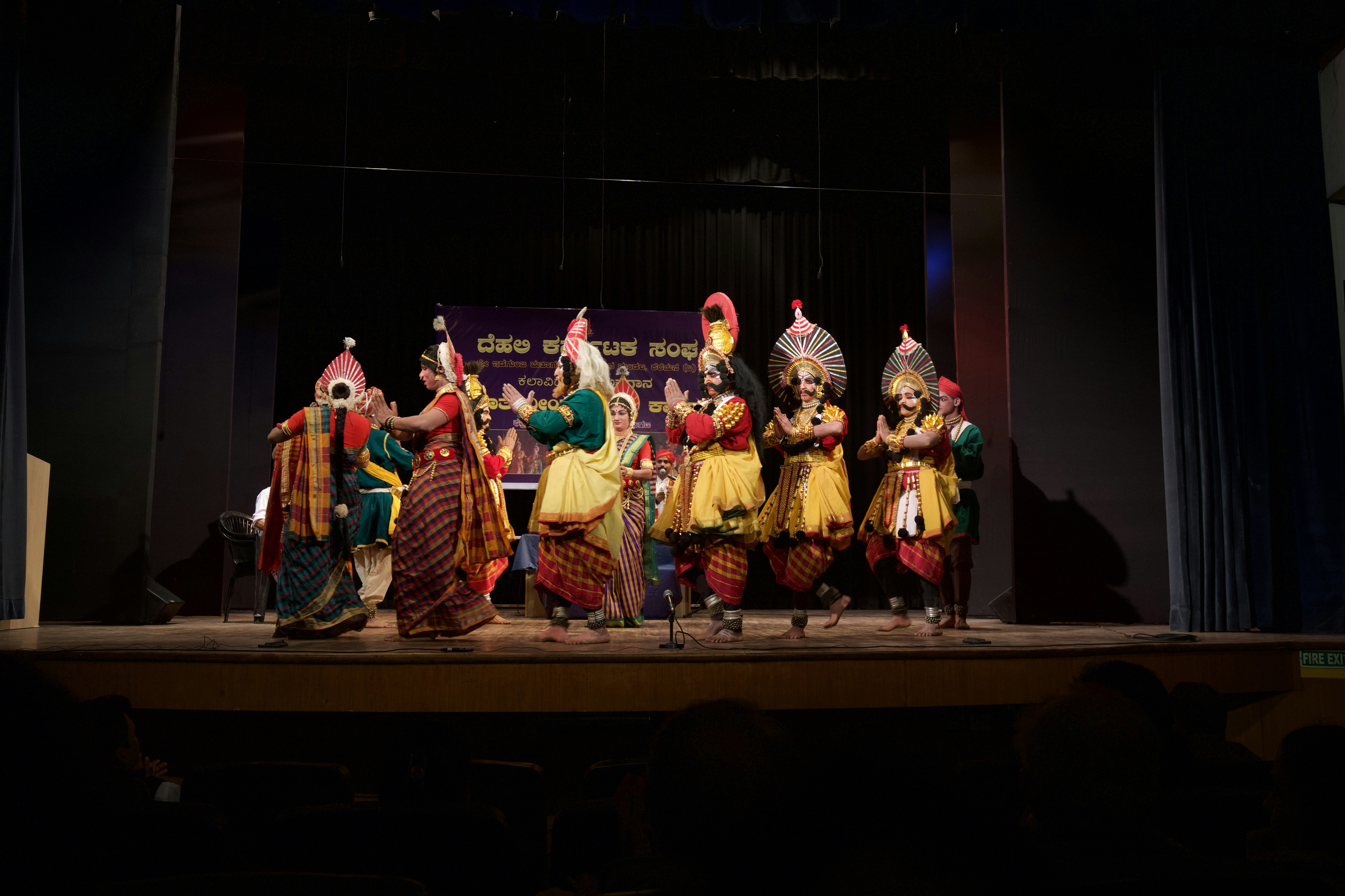 group of people in gold and red traditional dress dancing on stage