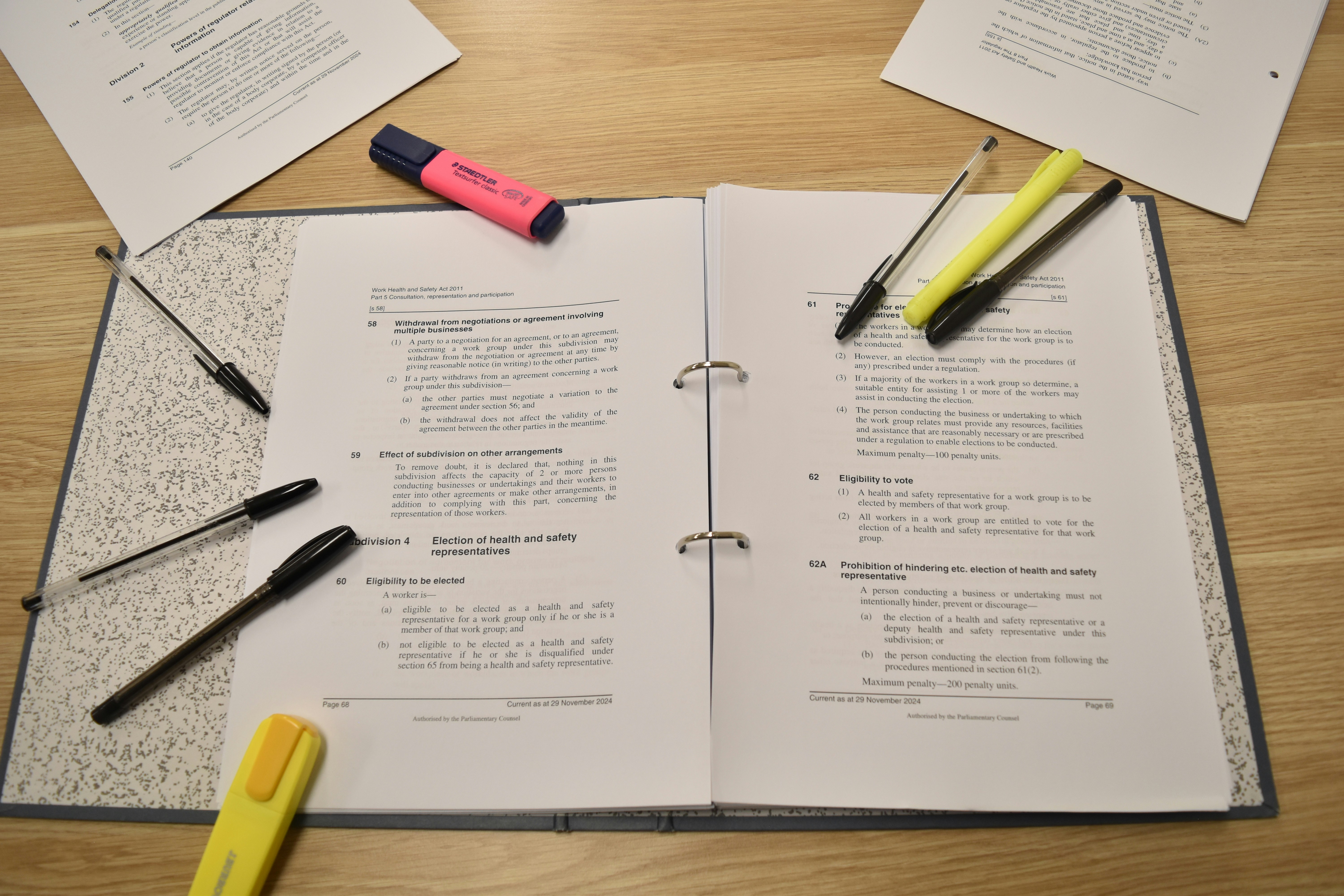 Papers, pens, and highlighters are laid out for studying.