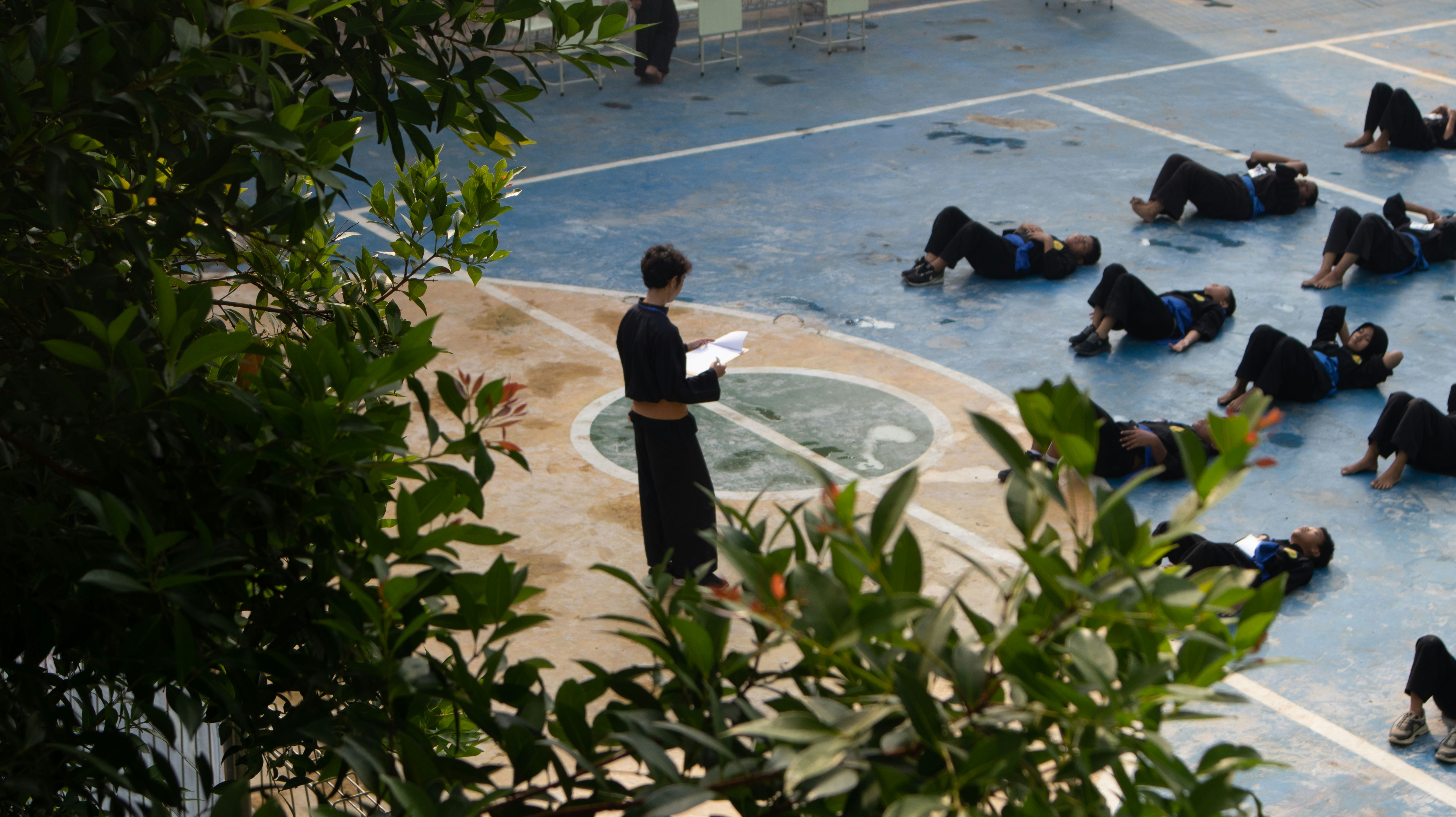 A group of people sitting on a basketball court