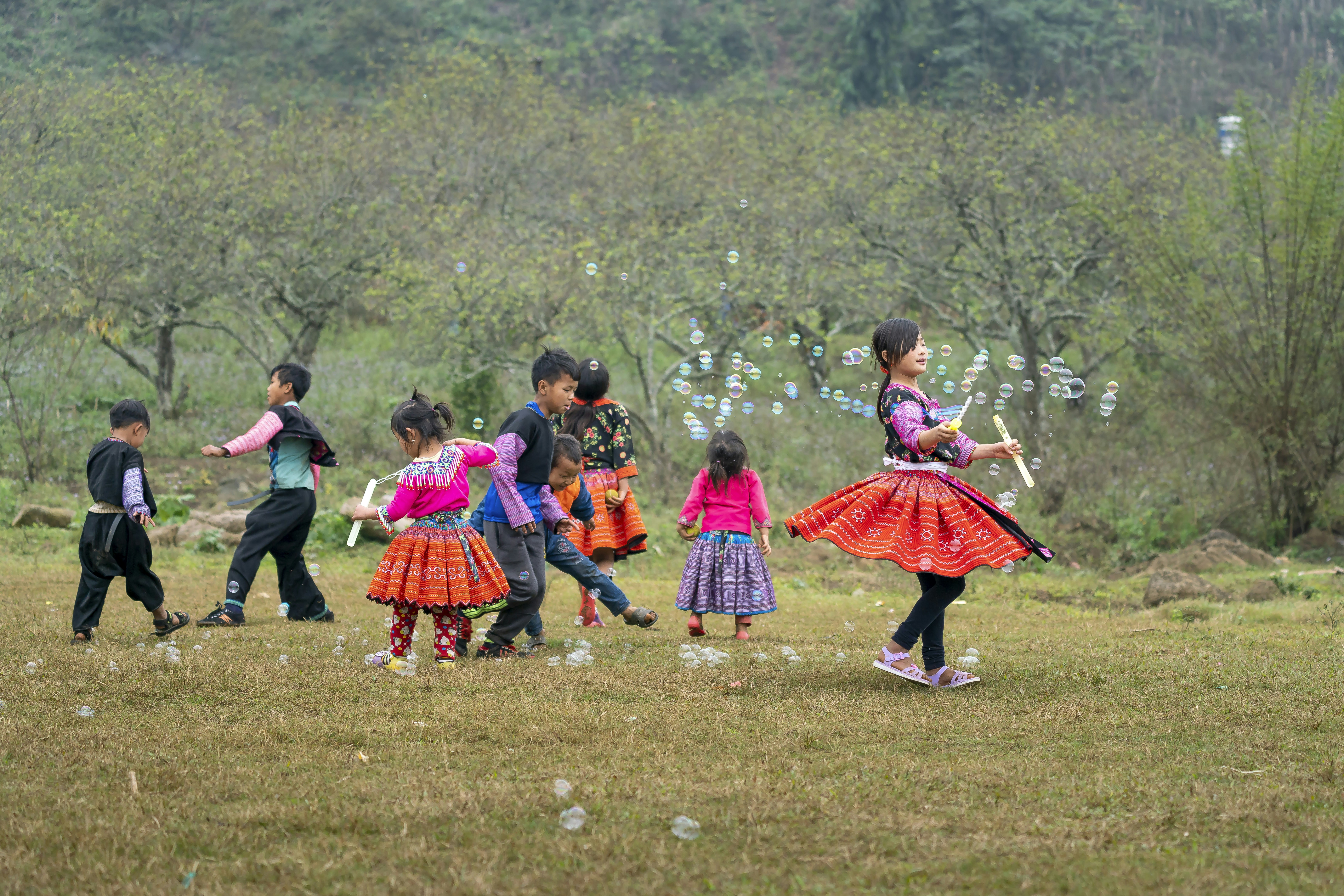 a group of children playing with bubbles in a field