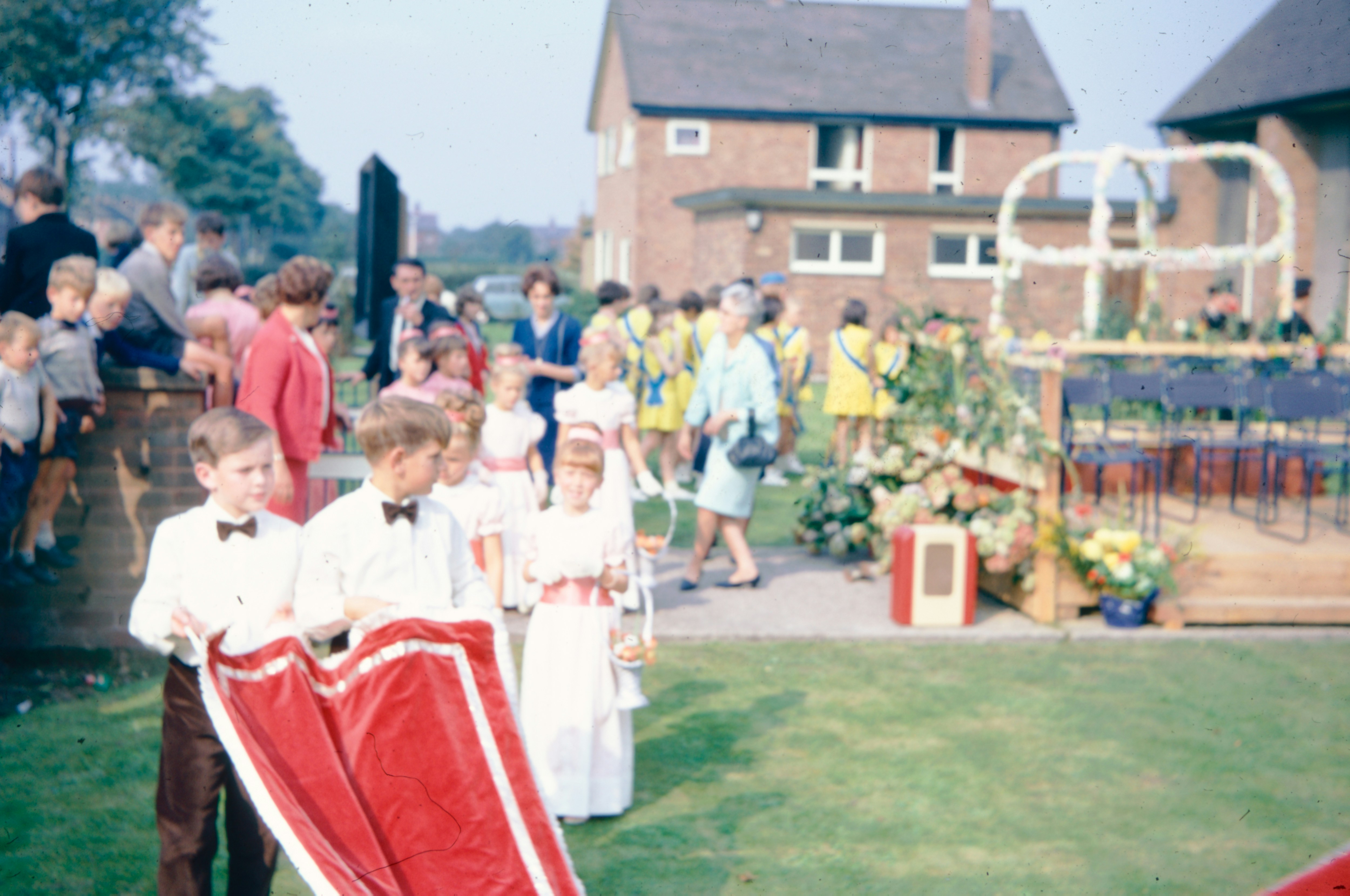 Children parade down the aisle during an outdoor ceremony.