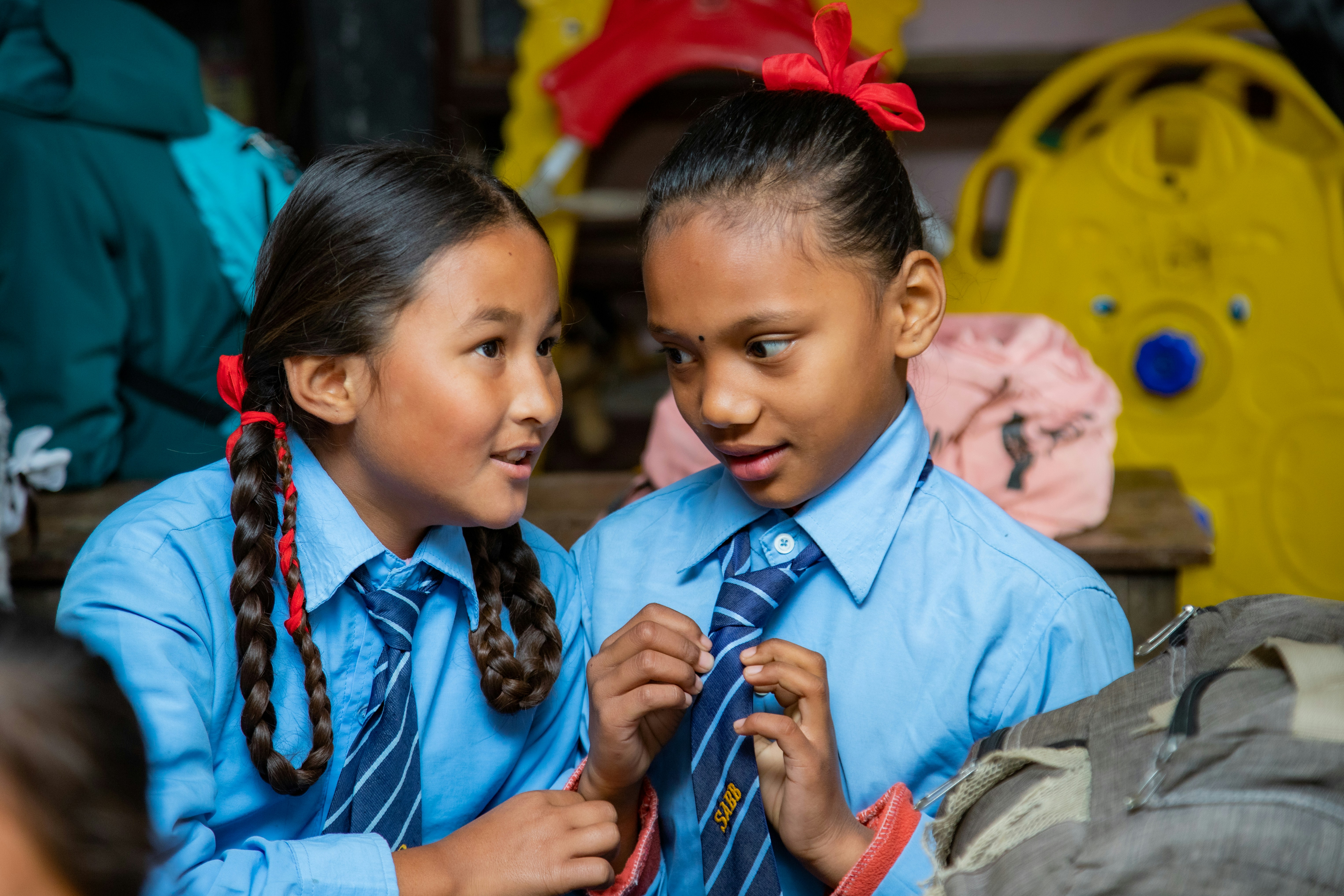 Two schoolgirls in uniform talking to each other