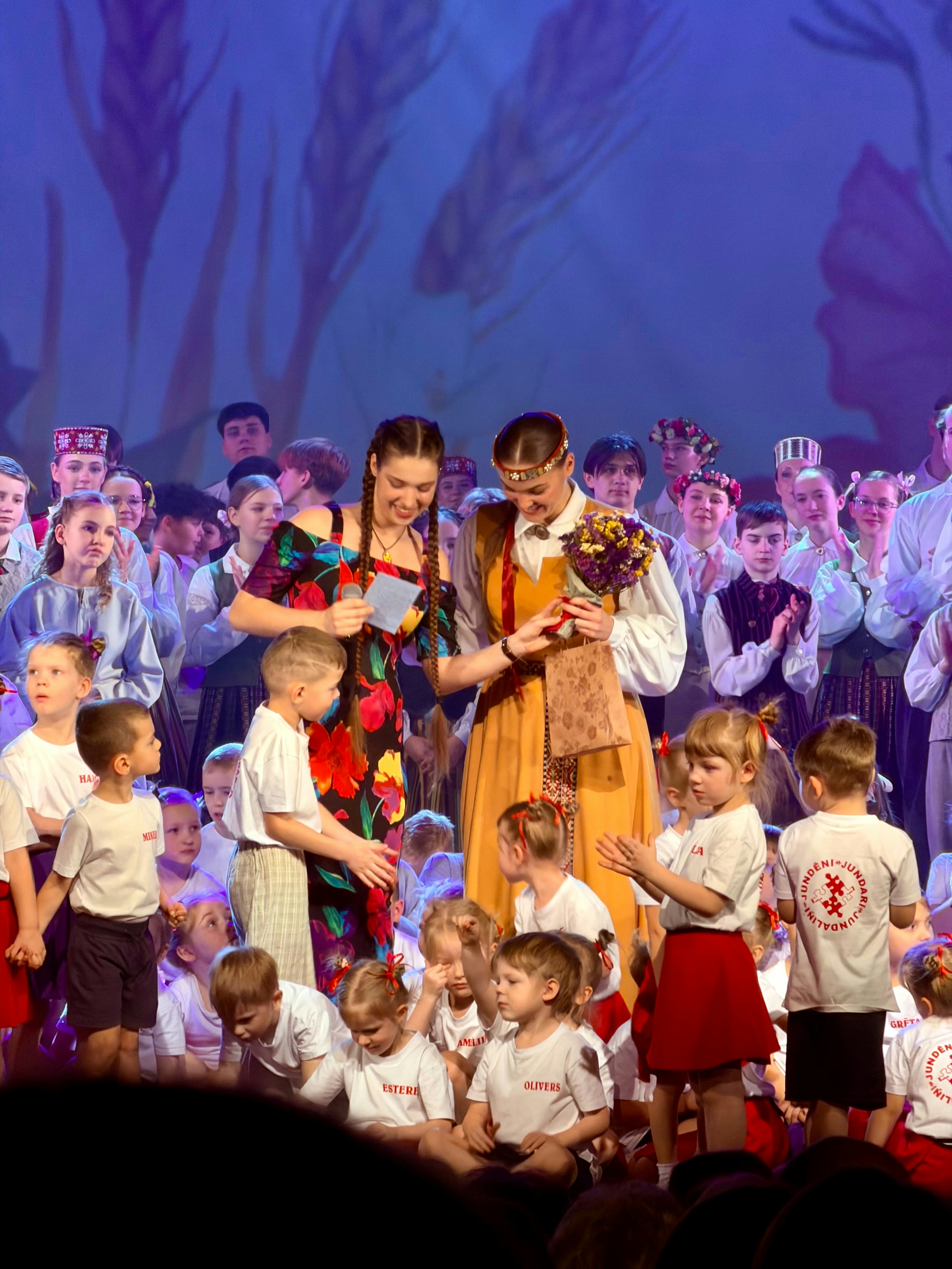 ✅ Conclusion by School Play Scripts Performers receive flowers on stage during a celebration.