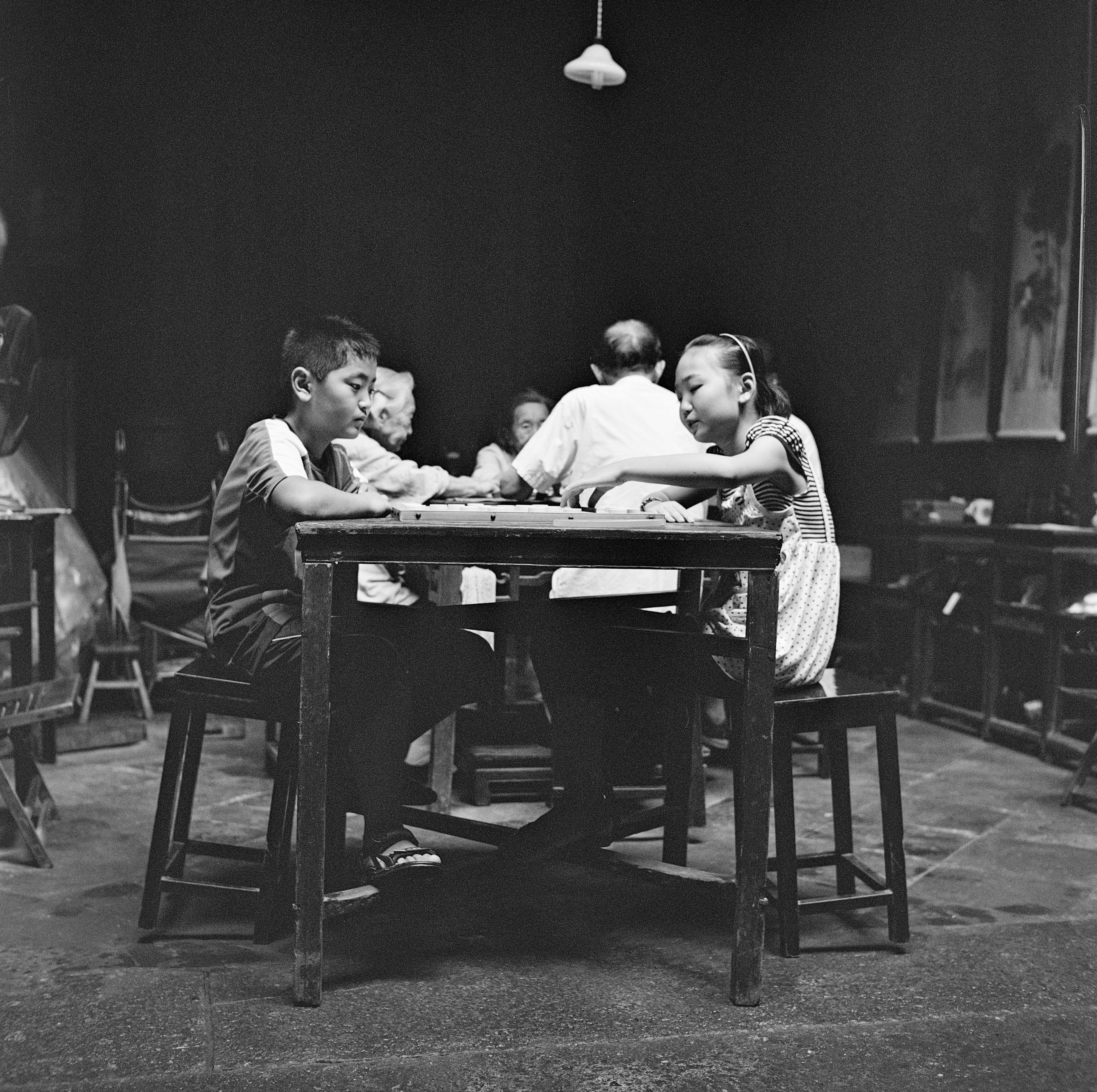 grayscale photo of 2 men sitting on chair