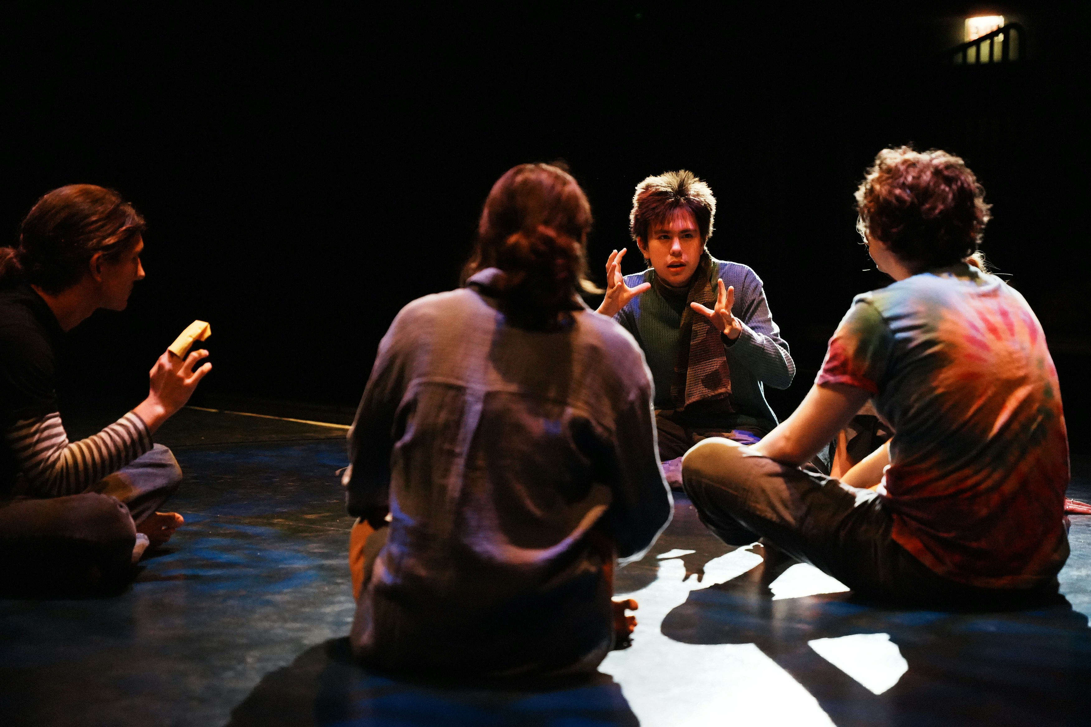 A group of people sitting on the floor talking
