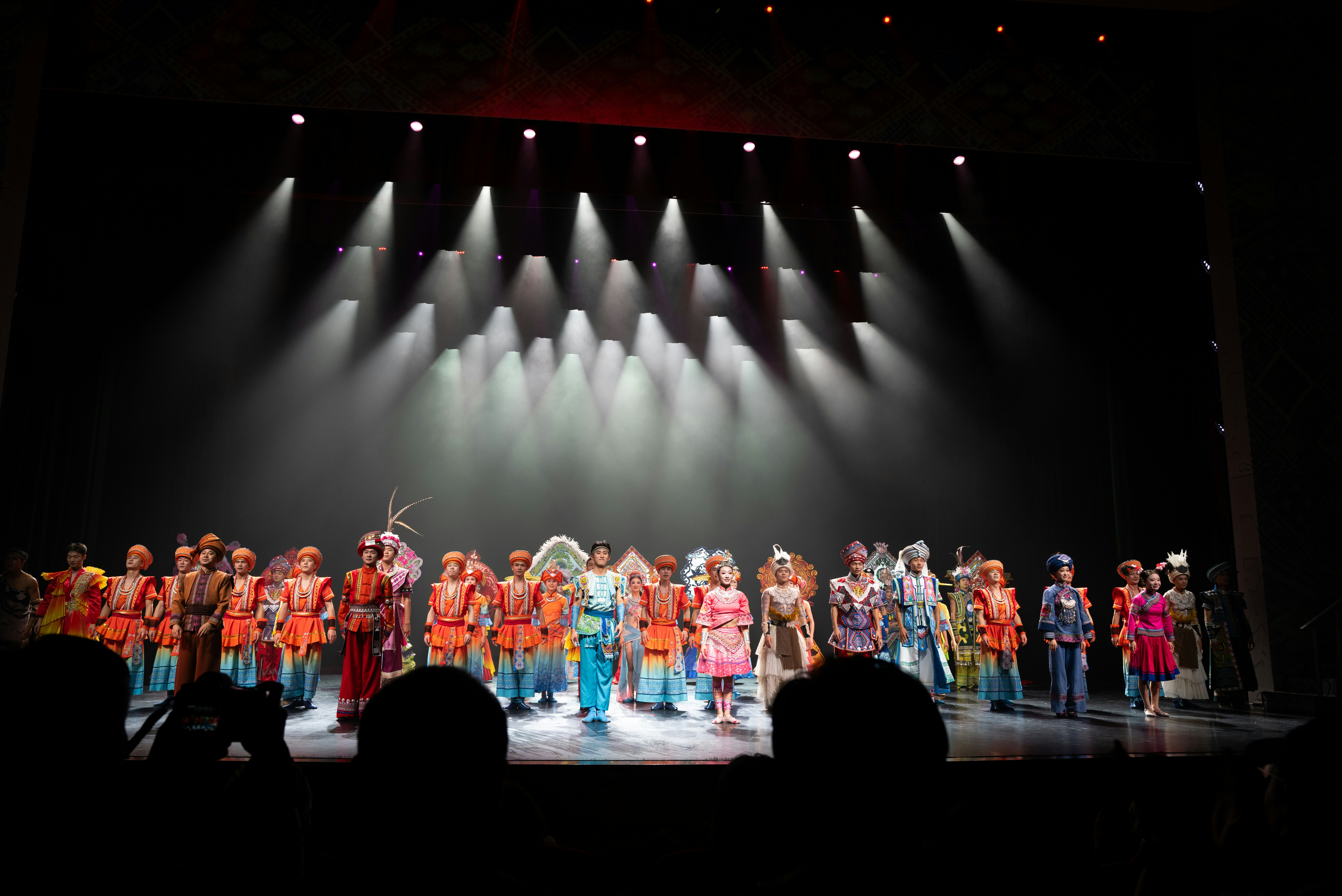 Performers in colorful costumes on a stage by School Play Scripts Performers in colorful costumes on a stage.