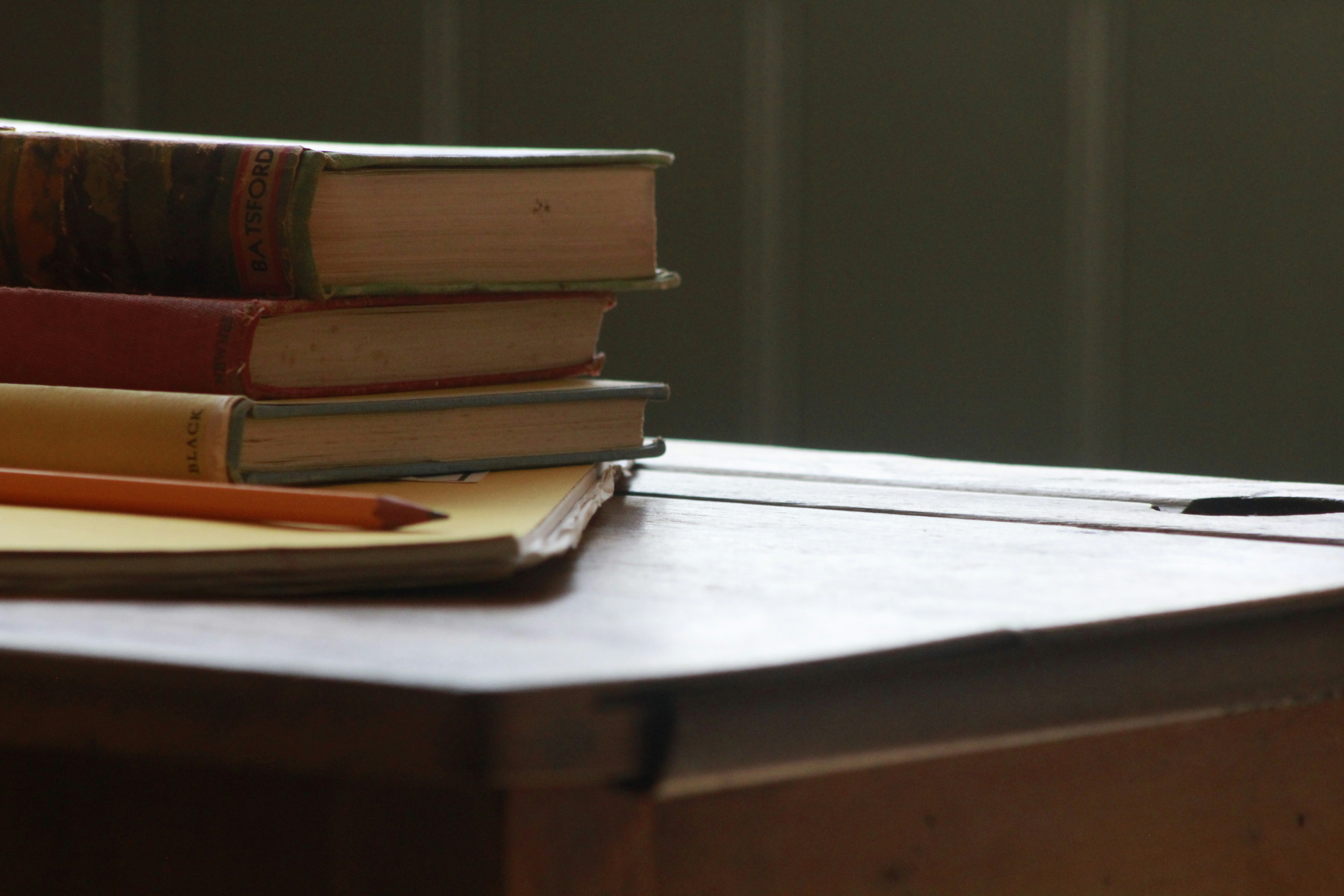 Vintage books on old school desk by School Play Scripts books and pencil on wooden table