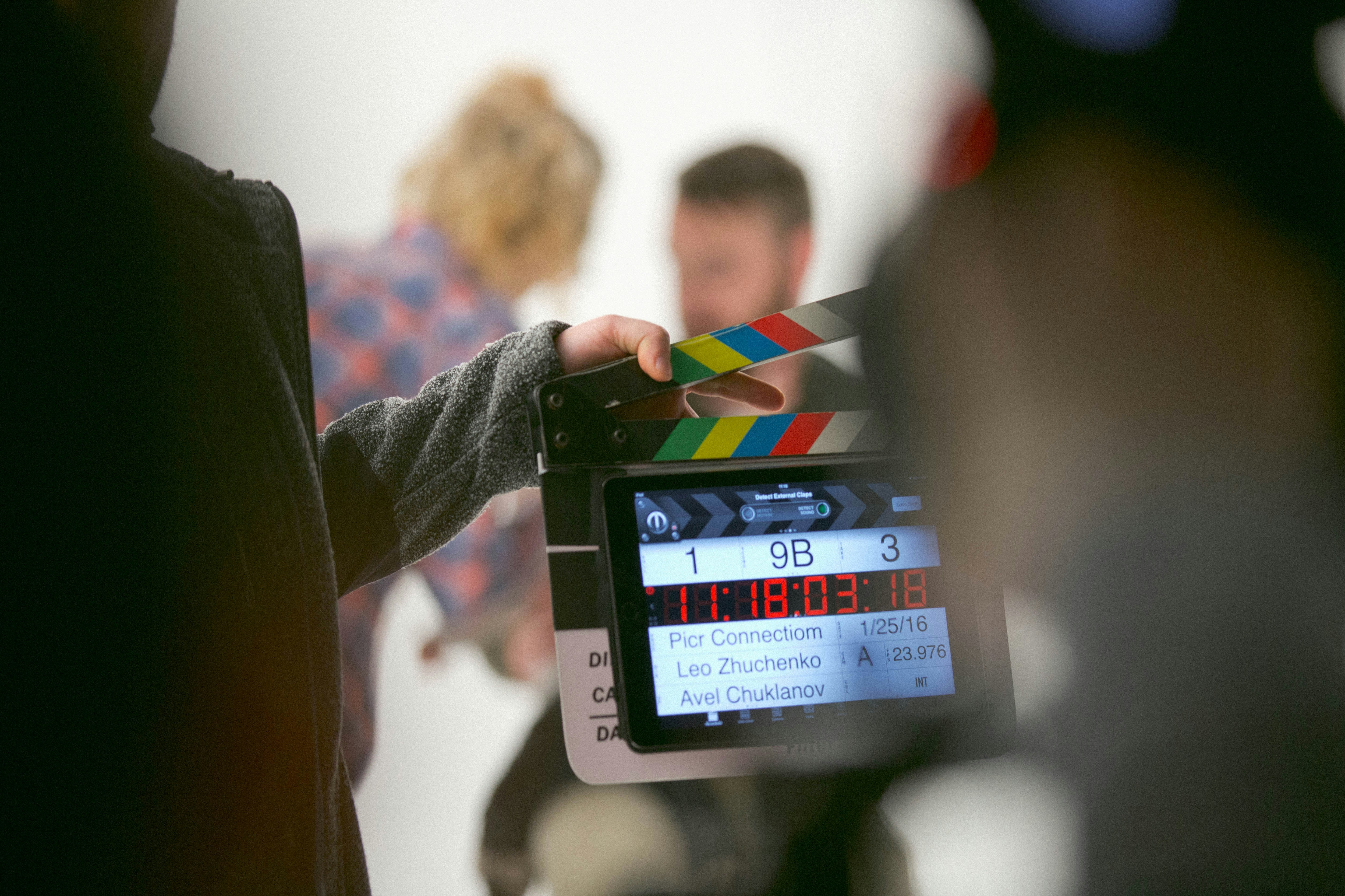 On set by School Play Scripts person holding clapperboard