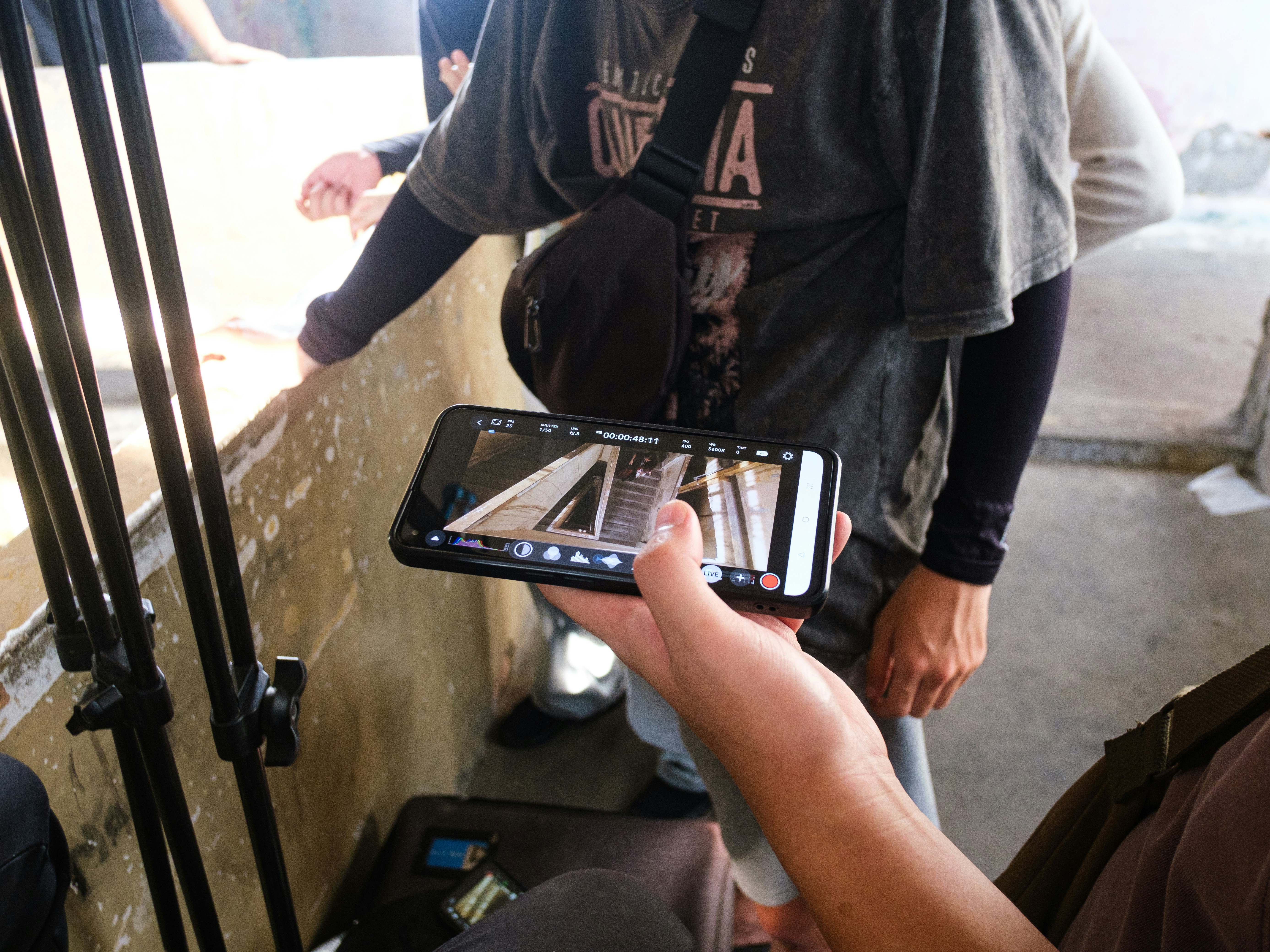 ❓ FAQ: Your Burning Questions About Digital Rehearsal Tools Answered by School Play Scripts Person holds smartphone displaying a street scene.