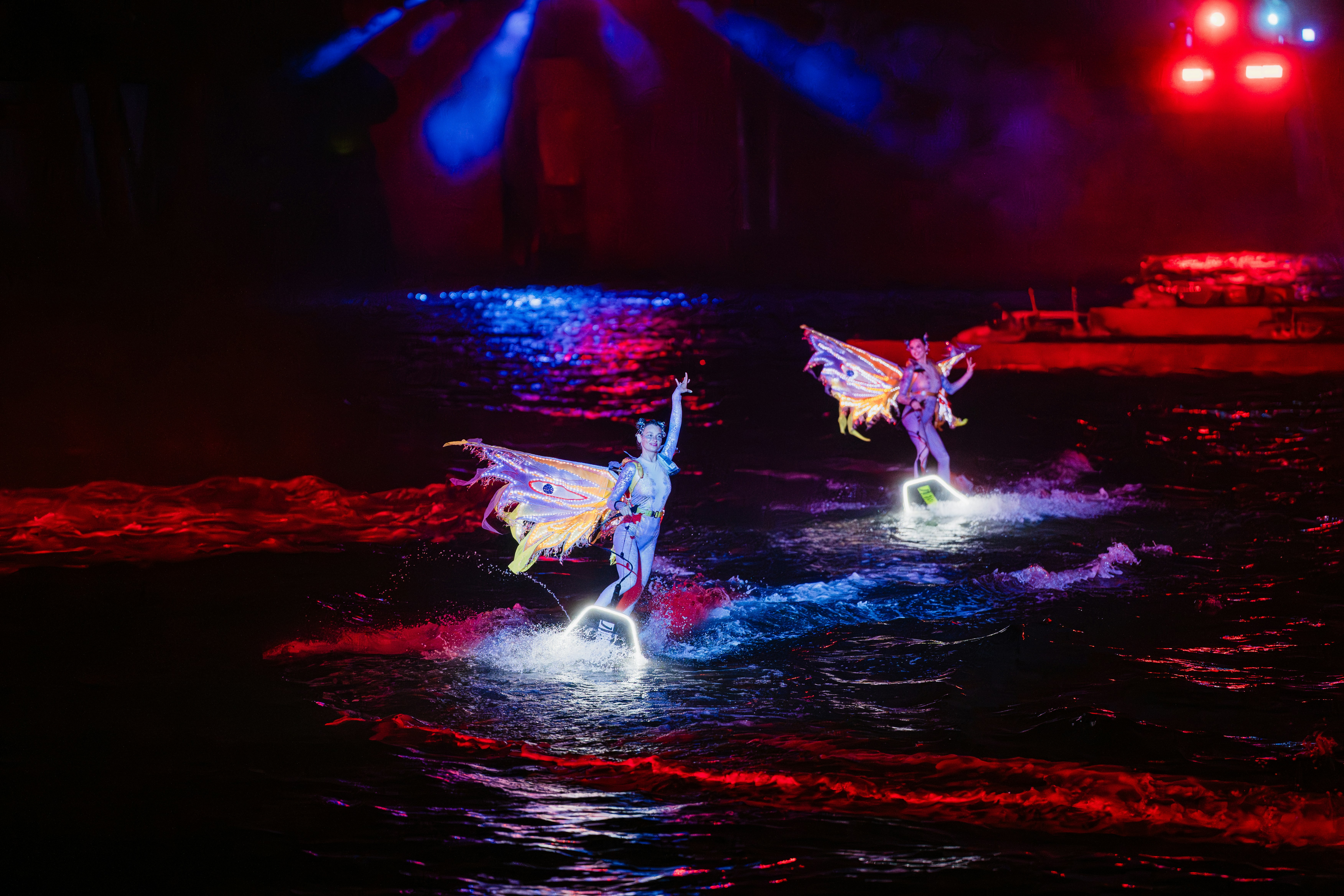 🏛️ The Evolution of the Wings: A History of Stagecraft by School Play Scripts Performers with wings on water at night