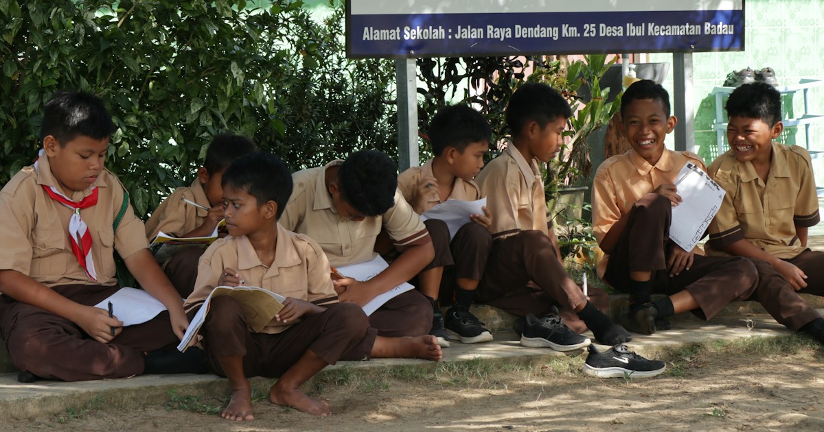 Conclusion by School Play Scripts Schoolboys in uniform sitting outdoors under a sign